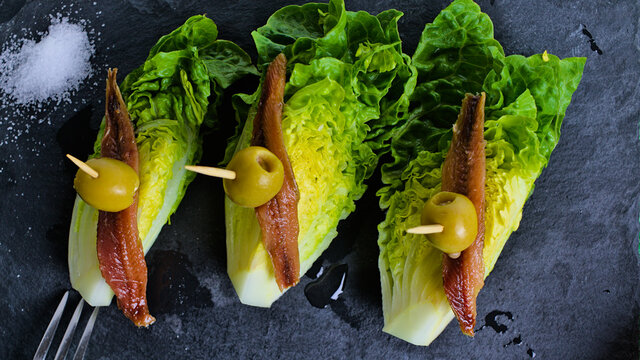 Aperitivo t&iacute;pico espa&ntilde;ol de cogollos de lechuga con anchoas y aceitunas llamado perdices, entrante muy utilizado en la dieta mediterr&aacute;nea 