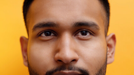 Obraz premium Close up portrait of young indian man with mustache isolated on yellow background. High quality photo