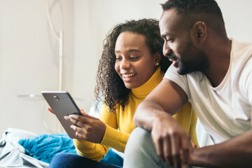 afro american couple watching tablet at home