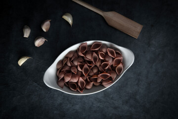Dark Food Photography Pasta on white dish, dark background, text space.