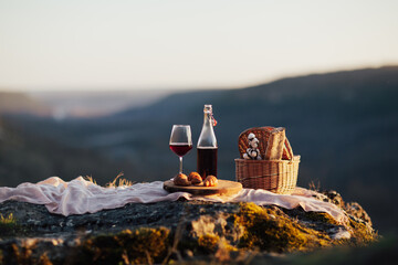 Delicious food and drink outdoor at picnic in sunny day. Romantic picnic with mountains background.