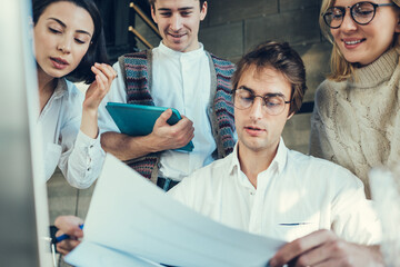 Group of millenials working together in loft office