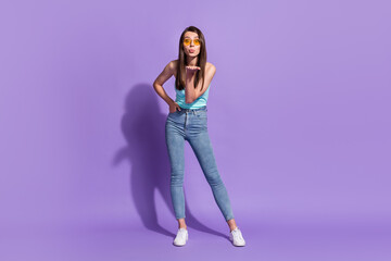 Fototapeta na wymiar Full size photo of flirty young happy woman send air kiss young wear sunglass isolated on purple color background