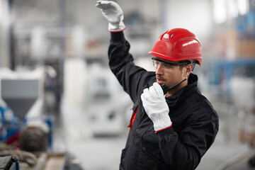 Portrait of worker in factory. Young man with helmet working in factory.