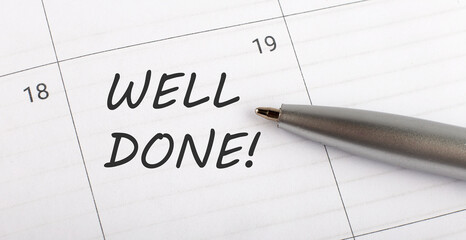 Text WELL DONE written on a calendar planner to remind you an important appointment with a pen on isolated white background.