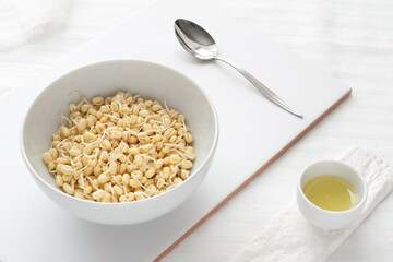 Raw sprouted mung bean in white bowl on a white tablecloth