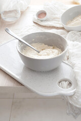 Fototapeta na wymiar Bowl of dough on a cutting board, and bowl of flour
