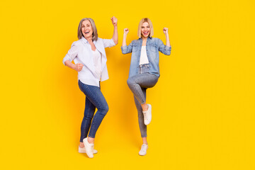 Full length body size photo of granddaughter and granny gesturing like winners isolated on bright...