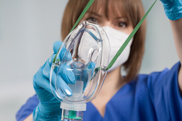 close up of a nurse applying disposable oxygen mask for breathing support from patient view