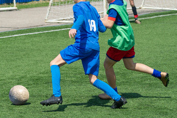 Children's football. An interesting football moment at the match and training. The active struggle and dynamics of the boys' soccer match. The boys are recklessly fighting for the ball