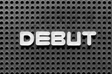 White alphabet letter in word debut on black pegboard background