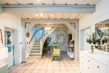 entrance to the cottage. Large hallway with wooden stairs and wooden ceiling. Interior of a country house with a lot of wood. House in Germany with white wooden stairs. 