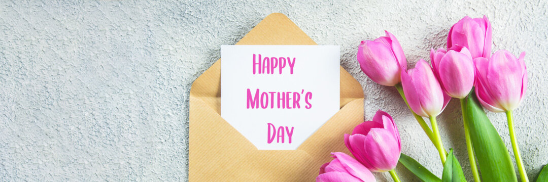 Mother's day Concept. Pink tulips, greeting card on concrete background. Flat lay. Banner image