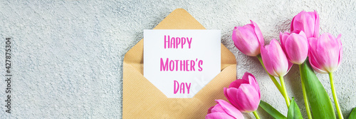 Mother's day Concept. Pink tulips, greeting card on concrete background. Flat lay. Banner image