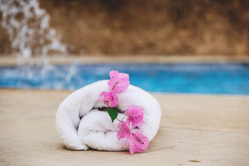 White towel with pink flowers near the spa pool in the hotel on vacation. High quality photo