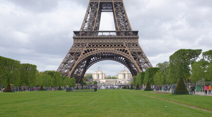 View of the Eiffel Tower from the Champ de Mars. Nearby walk tourists