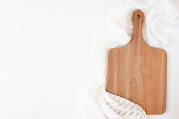 Wooden cutting board on white napkin and concrete background