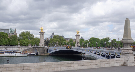Fototapeta na wymiar View of the Pont Alexandre lll. On the bridge are pedestrians