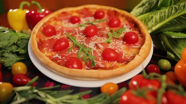 Serving a Pizza with Jamon, Tomato, Peppers, Parmigiano and Rucula.
