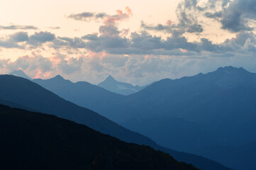 Mountain silhouettes and clouds highlighted by the sun