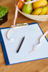 Top view of Nutritionist, dietitian workplace with measuring tape and bowl with healthy vegetables and fruits