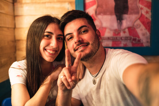 Closeup shot of a white Caucasian girl and a boy showing peace signs