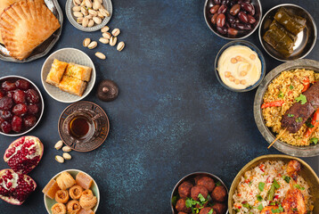 Ramadan kareem Iftar party table with assorted festive traditional Arab dishes, sweets, dates. Eid al-Fitr mubarak evening grand meal, top view. Islamic holidays food, Ramadan feast, space for text
