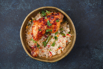 Grilled chicken and rice with vegetables in rustic metal plate on blue stone background top view. Middle Eastern or Indian meal for lunch or dinner, from above
