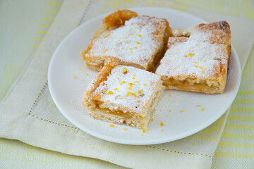 Lemon tart with filling, icing sugar and lemon zest