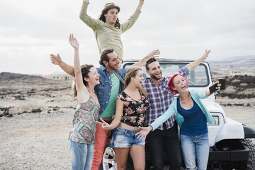 Crazy group of friends doing selfie outdoors during trip excursion in convertible 4x4 car - Travel concept - Focus on bottom faces © DisobeyArt