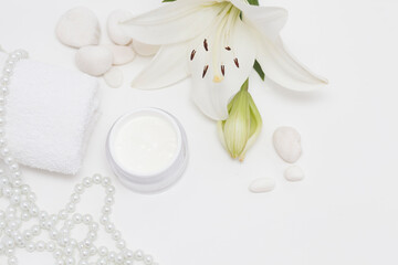 Fototapeta na wymiar Lily (Lilium candidum) face cream with white towel, peals, Lilium fresh flower and sponges, isolated white