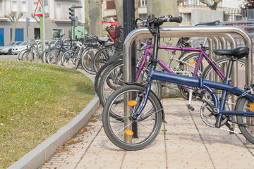 Bicycles of different colors and shapes parked in a parking lot or place to hold them in the middle of the city with the concept of urban mobility