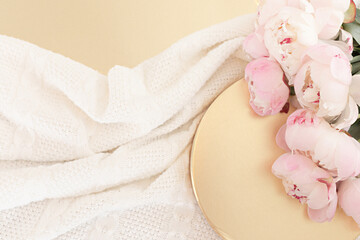 Styled composition with pink tulips on gold background. Flat lay floral frame and white textile. Border top view.