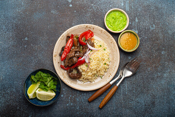 Traditional dish of Peru Lomo saltado made of beef tenderloin with peppers served on ceramic plate with rice and salsa from above, Peruvian cuisine 