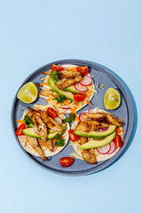 Tacos with crispy fish, avocado, guacamole sauce and lime on blue background. Top view with copy space. - 427885761