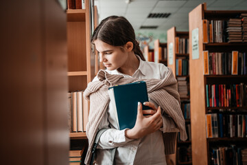 education, high school, university, learning concept - smiling student girl reading book at library