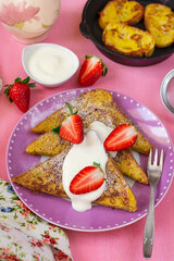 Sweet French toasts served with whipped cream and strawberries