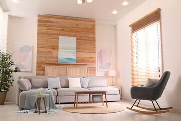 Stylish living room interior with comfortable sofa and pictures