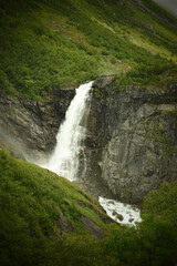 Fototapeta na wymiar Waterfall, montains and gloomy weather, dramatic landscape