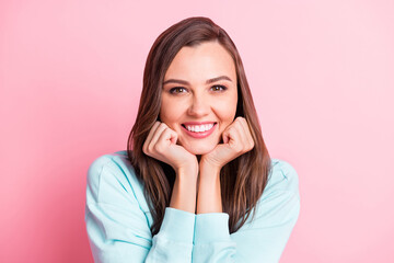 Photo of adorable attractive young woman hold fists cheeks good mood smile isolated on pink color background