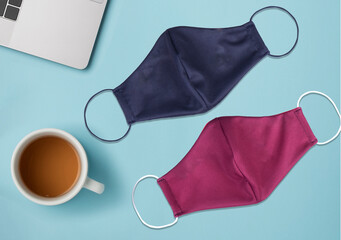 Protective mask covid-19 black and Magenta color fabric Industrial. on desk office blue sky and cup tea.