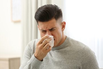 Ill man with paper tissue at home