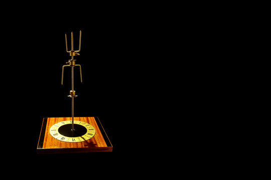Abstract object on black background. Vintage wall clock with a metal rotary mecanism in the centre.