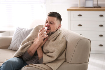Man suffering from runny nose at home
