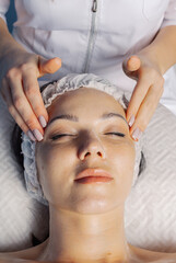 Fototapeta na wymiar Professional beautician makes a facial massage to a woman.