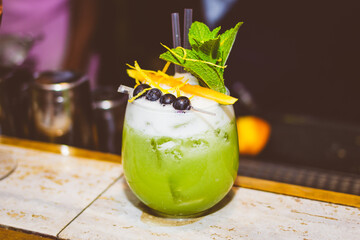 Fancy green cocktail drink at bar