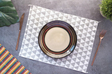 cutlery and empty plate on wooden background top down