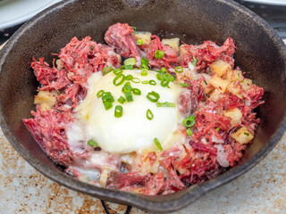 Baked beef with pouched egg in black bowl decoration, selective focus