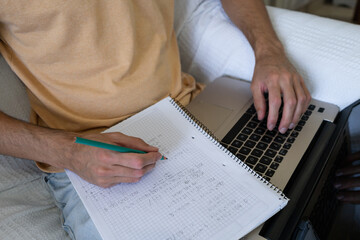 Close-up of a person studying mathematics and solving practical exercises with equations.