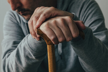 Man holding walking stick, close up of hands